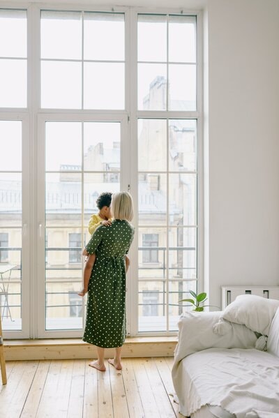 Mother holding child at a sunlit window